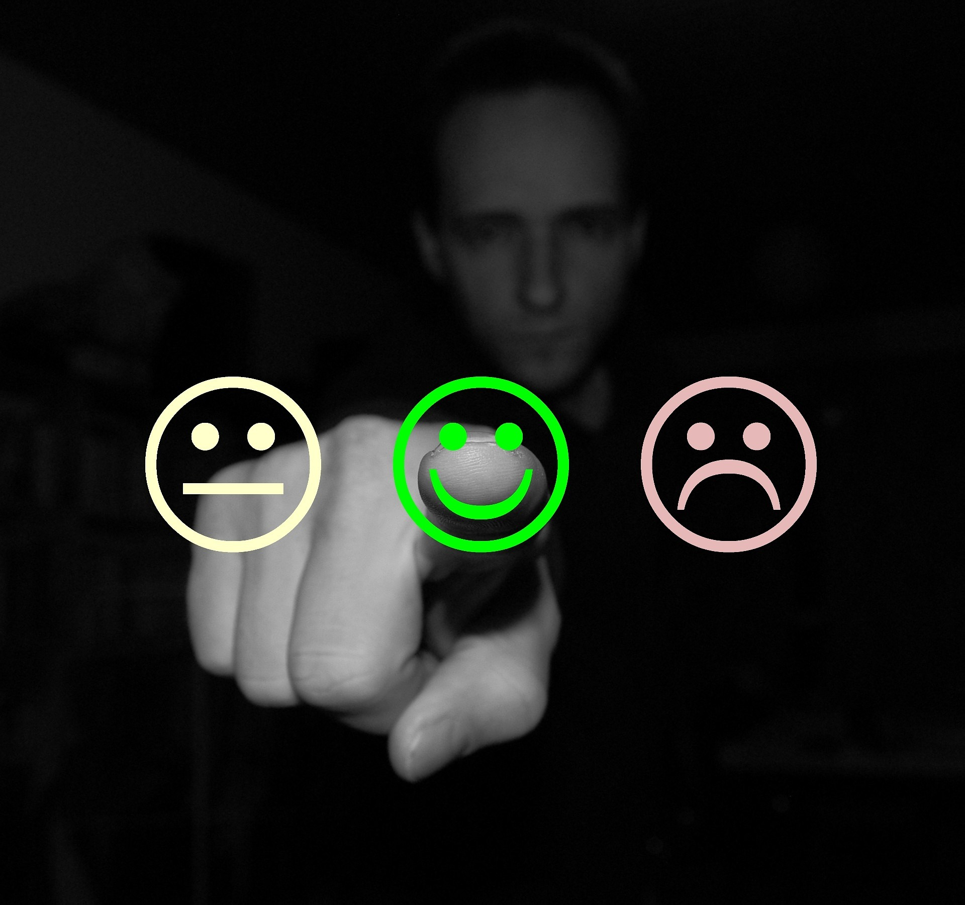 Mann vor Auswahl aus traurigen und frohen Smileys